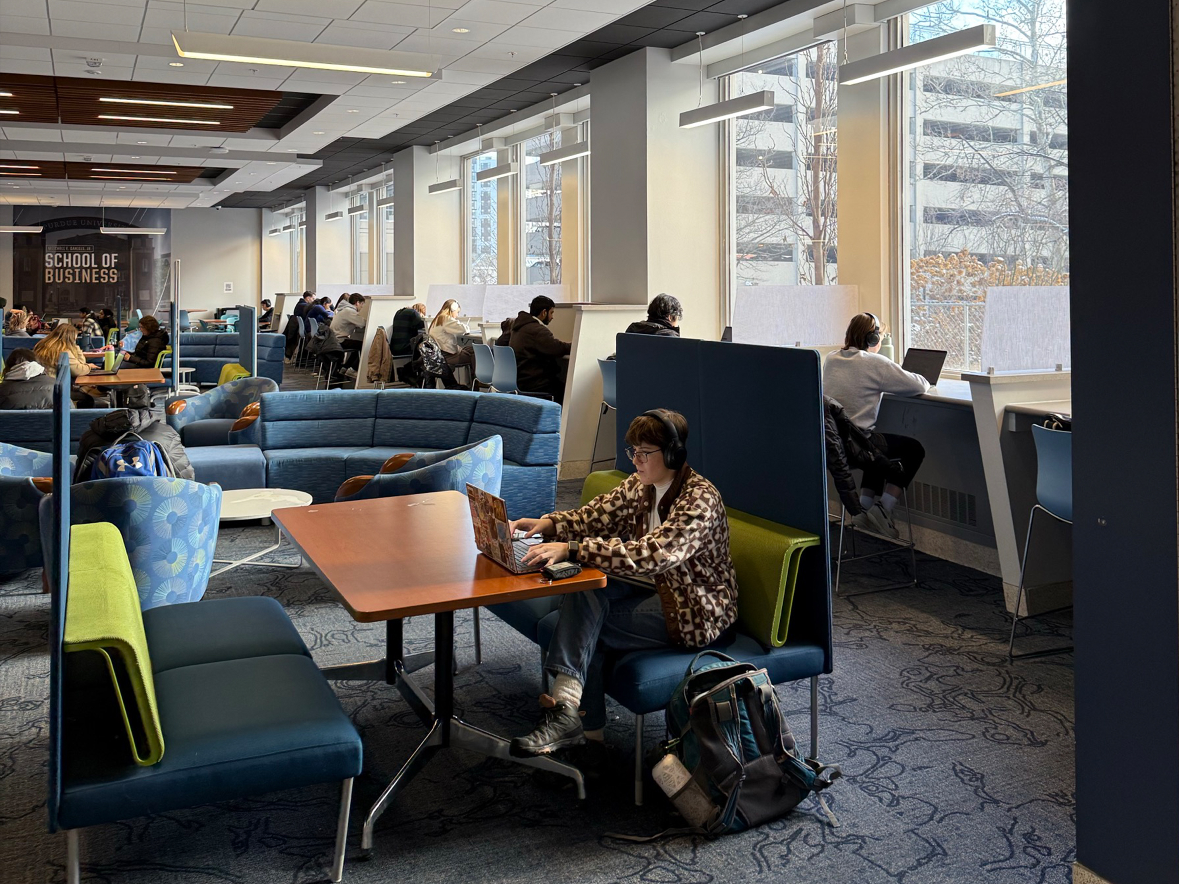 people working wirelessly in common area of a college